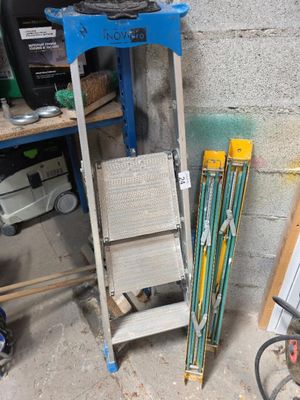 Plusieurs paires de skis et de bâtons de ski sont empilés sur une étagère dans un garage.