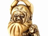 a small statue of a man holding a baby