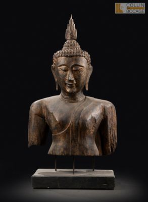 une statue en bois représentant un Bouddha sur fond noir