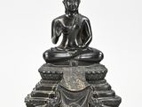 a bronze figure of a seated buddha on a pedestal
