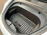a trunk of a car that has a black floor mat in it