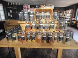 many jars of spices on a table in a store
