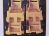 two yellow toy trucks that are on display in a box