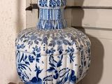 a blue and white vase sitting on a wooden table