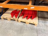 two pallets with red plastic pieces on them in a warehouse