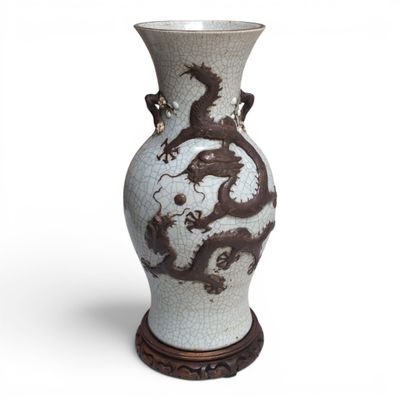 un vase orné d'un dragon, posé sur un socle