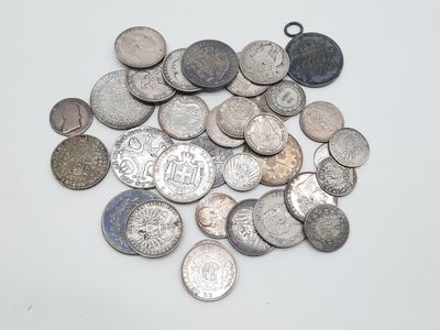 plusieurs types différents de pièces d'argent sur une surface blanche