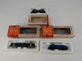 trois trains miniatures dans leurs boîtes, empilés les uns sur les autres