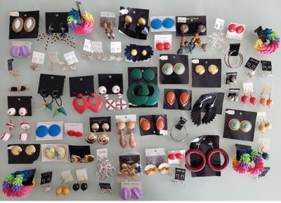 many pairs of earrings on display on a wall