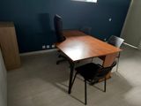 a desk with a chair and a window in the room