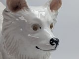 a white dog figurine that is sitting on a table