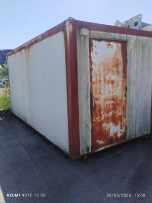 un conteneur rouillé abandonné au bord de la route