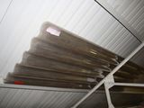 many rolls of plastic sitting on a rack in a room