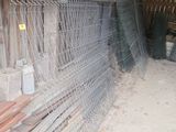 a pile of wood and a fence in a barn