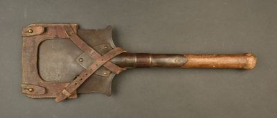 a close up of a wooden handled shovel on a gray surface