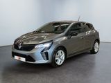 Une voiture argentée est garée dans une pièce aux murs blancs