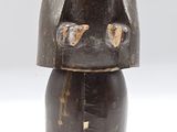 an old wooden figurine of a man with a hat on his head