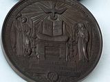 une médaille de bronze sur laquelle figurent un homme et une femme