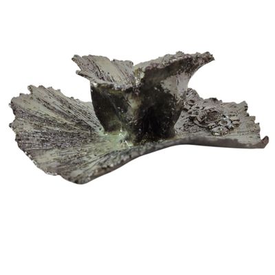 une statue représentant un oiseau perché sur une feuille