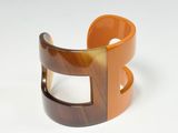 a brown and orange bracelet with a square design on it