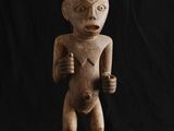 une statue en bois représentant un homme tenant un couteau à la main