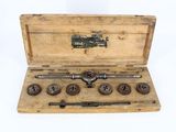 a wooden box with tools in it on a white surface