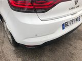 the rear end of a white car parked in a parking lot