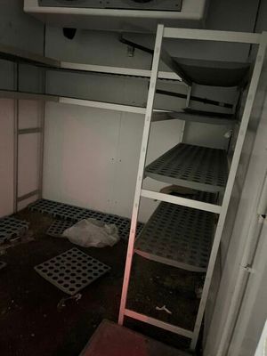 a small room with a ladder and a microwave on the wall