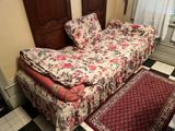 un lit avec une couette à motifs floraux et un tapis au sol