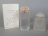 l'image d'un flacon de parfum à côté d'une boîte de parfum