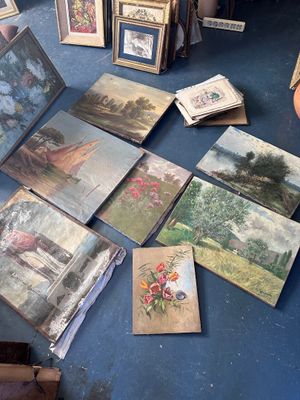 il y a beaucoup de tableaux par terre dans cette pièce