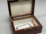 a small wooden box with a metal handle inside of it