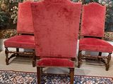 two red chairs sitting on top of a rug in front of a tapestry