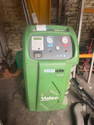 an image of a green machine in a garage with a hose