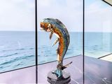 a statue of a fish that is on display in a glass case