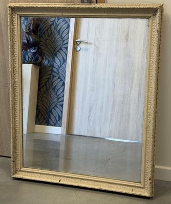 un grand miroir posé par terre près d'une porte