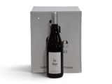 la bouteille de vin est à côté de la boîte sur la table