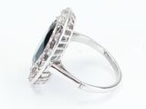 a close up of a ring with a blue stone surrounded by diamonds