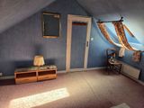 a room with a bed, a dresser, and a window
