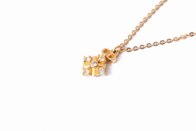 un gros plan d'un collier en or orné d'un petit diamant