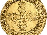 a gold coin with a cross and a crown on it