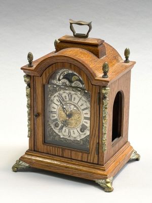 une petite horloge en bois posée sur une table