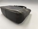 black leather purse on a white surface with a white background