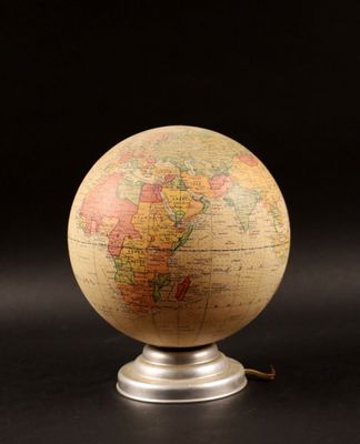 a close up of a small globe on a stand on a black surface