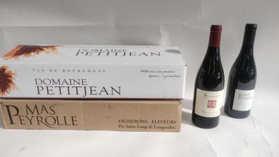 two bottles of wine sit next to a stack of books