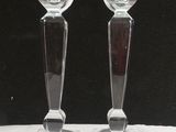deux bougeoirs en verre transparent posés sur une table