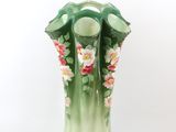 a green vase with pink flowers on it on a white background