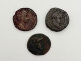 three roman coins, one of which has a head and one of which has a face