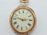a gold pocket watch with roman numerals on the face