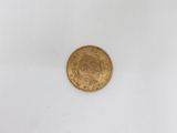 a close up of a gold coin on a white surface
